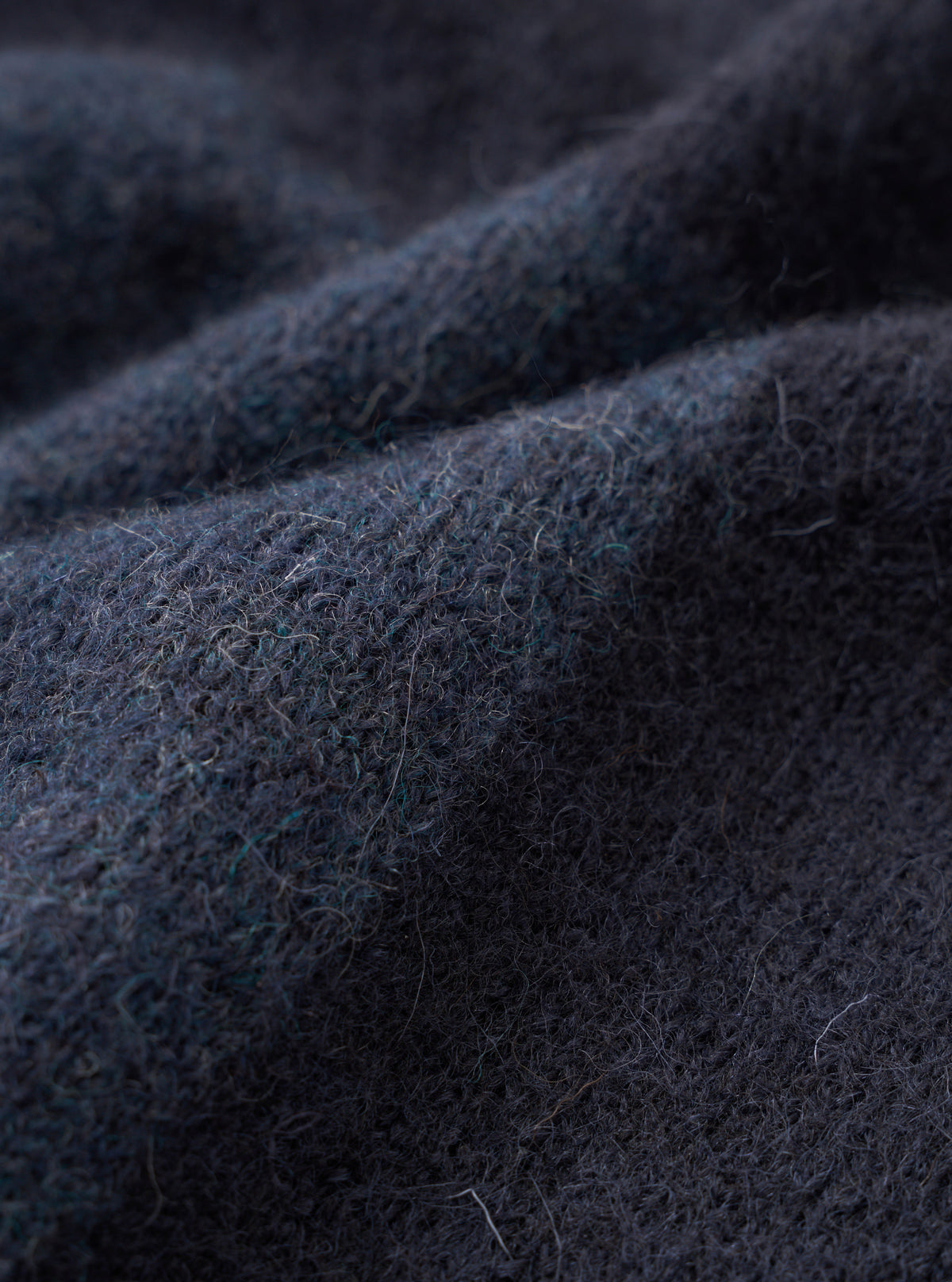 A close-up fabric swatch shot of the Navy British Wool Lyon Crew sweater. Focuses on the rich marled texture and dense weave of the navy blue British wool yarn, presented clearly against a plain white background.