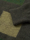 Close-up detail view of the Olive British Wool Lyon Crew sweater against a stark white studio background. Focuses on the ribbed crew collar, raglan sleeve construction, and fine texture of the olive green British wool yarn.