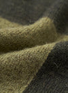A close-up fabric swatch of the Olive British Wool Lyon Crew sweater. The detailed shot emphasizes the rich marled pattern, soft depth, and heavy weave of the olive green British wool material against a clean white background.