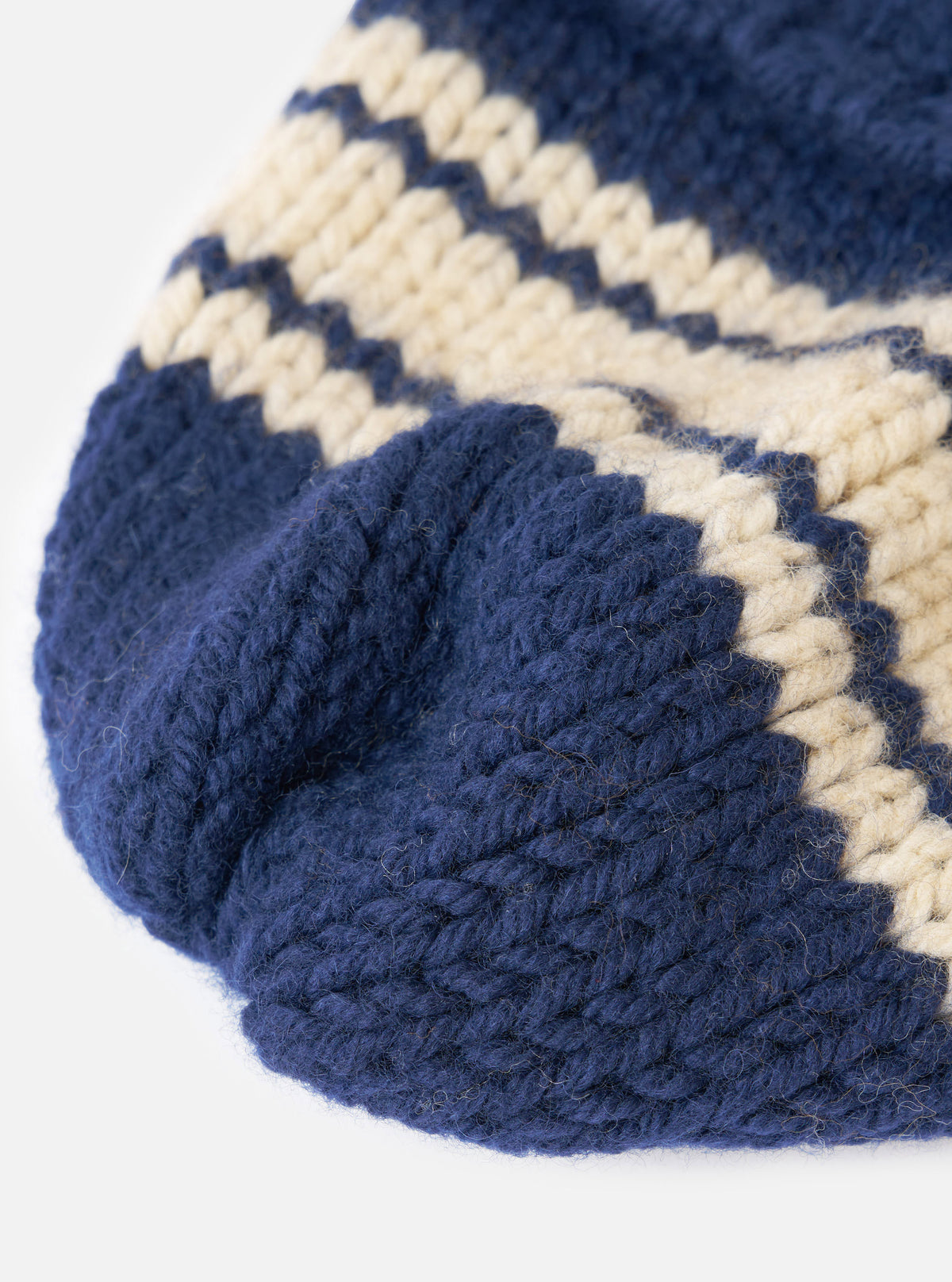 A detailed close-up shot of the Navy Chunky Knit Stripe Lenny Hat set on a plain white background. The photo emphasizes the soft chunky wool fabric, precise knitted stripe detailing, and turn-up brim.