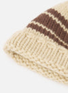An angled side shot of the Ecru Chunky Knit Stripe Lenny Hat on a clean white background. The image highlights the chunky wool knit construction, soft ecru tone, and folded hem detail of the hat.