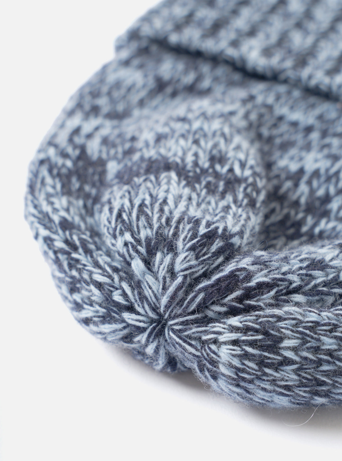 A close-up shot focusing on the crown and cuff of the Sky/Navy Lambswool Watch Cap against a solid white background, emphasizing the fine knitted lambswool texture and sky blue color blend.
