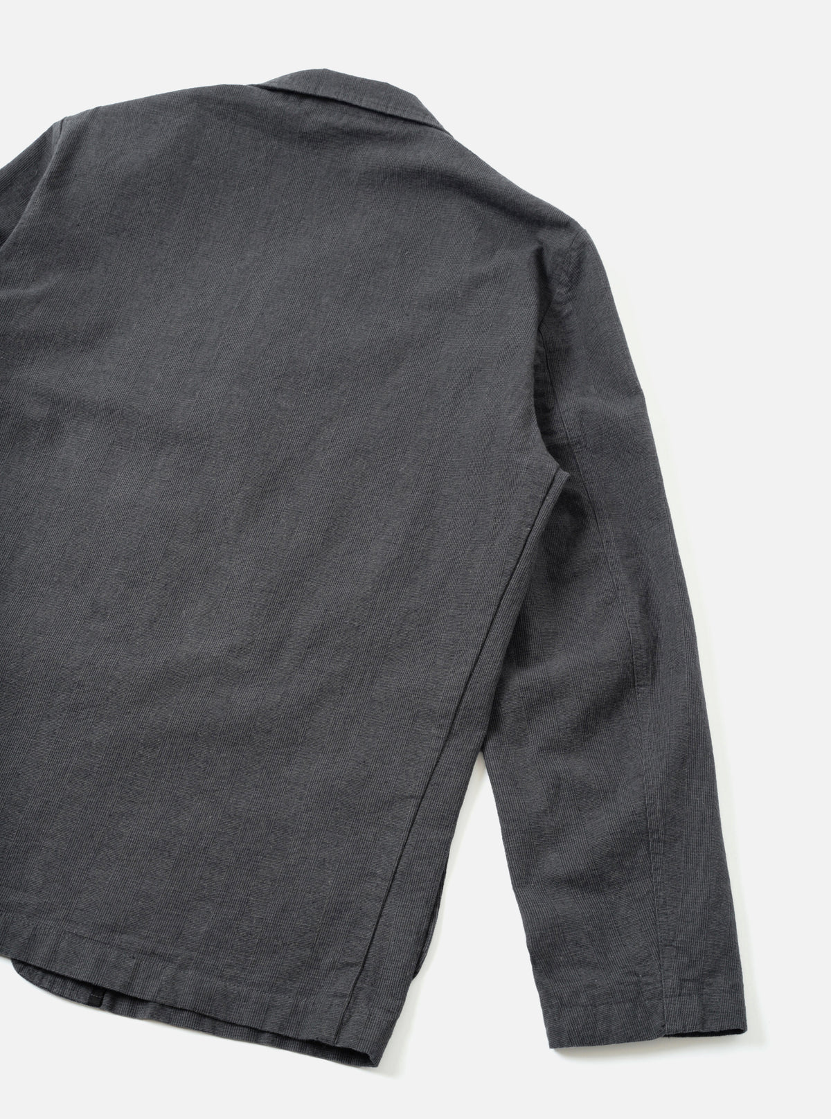 A back view of the Grey Liverpool Check Three Button Jacket shown against a clean white studio background. The shot highlights the tailored silhouette, center back vent, smooth shoulders, and fine grey check cotton-linen pattern.
