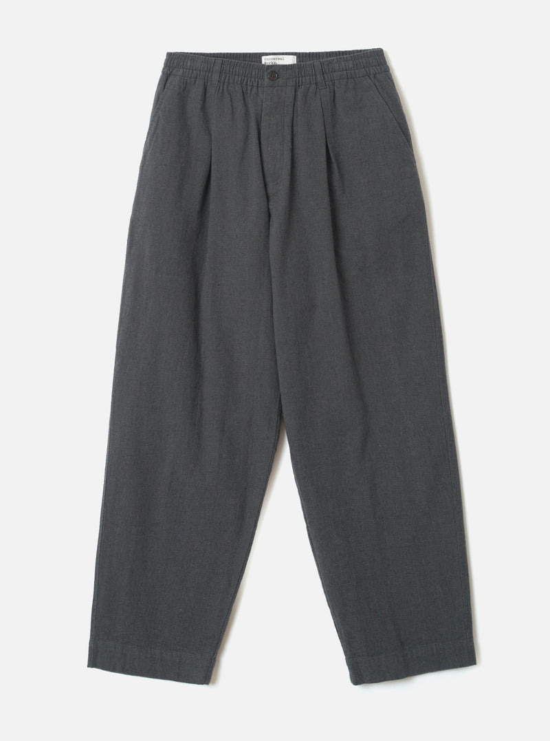 A front view of the Grey Liverpool Check Oxford Pant laid out flat against a plain white background. The loose-fit trousers feature a drawstring waistband, front pleats, side pockets, and a subtle grey cotton-linen check weave.