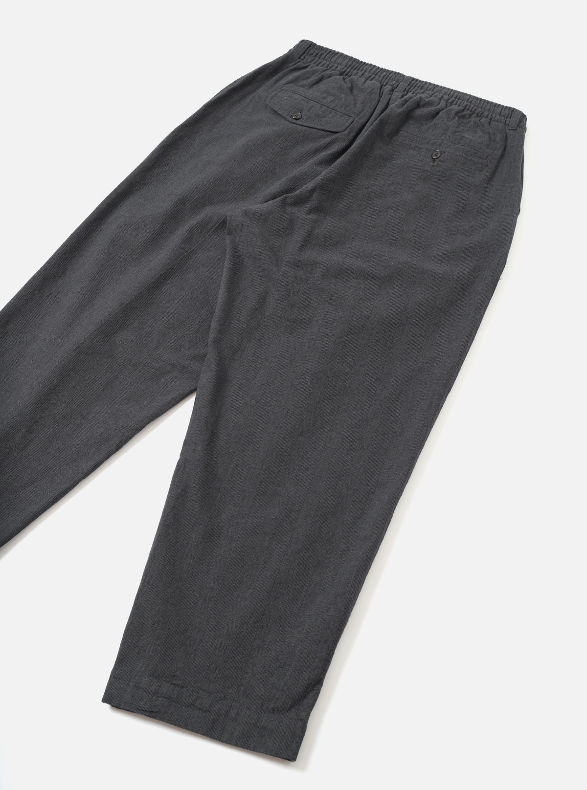 A back view of the Grey Liverpool Check Oxford Pant presented against a clean white studio background. The image displays the comfortable wide-leg cut, rear welt pockets, and grey check cotton-linen fabric construction.