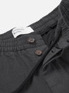A detailed close-up shot of the waist area of the Grey Liverpool Check Oxford Pant on a solid white background, highlighting the drawstring closure, pleated waist construction, and grey check cotton-linen textile texture.