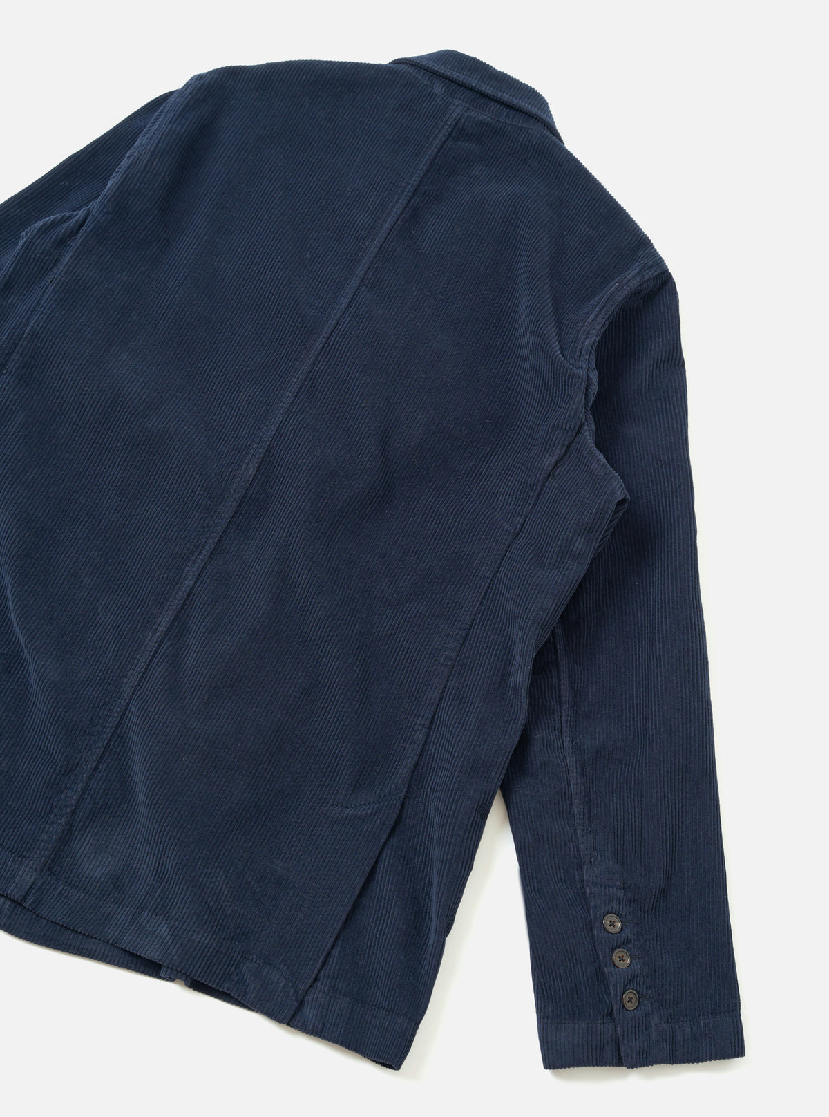 A back view of the Dark Navy Cord Manor Jacket against a clean, plain white background. The image showcases the fine corduroy texture, straight hemline, structured rear shoulders, and navy cotton stitching.