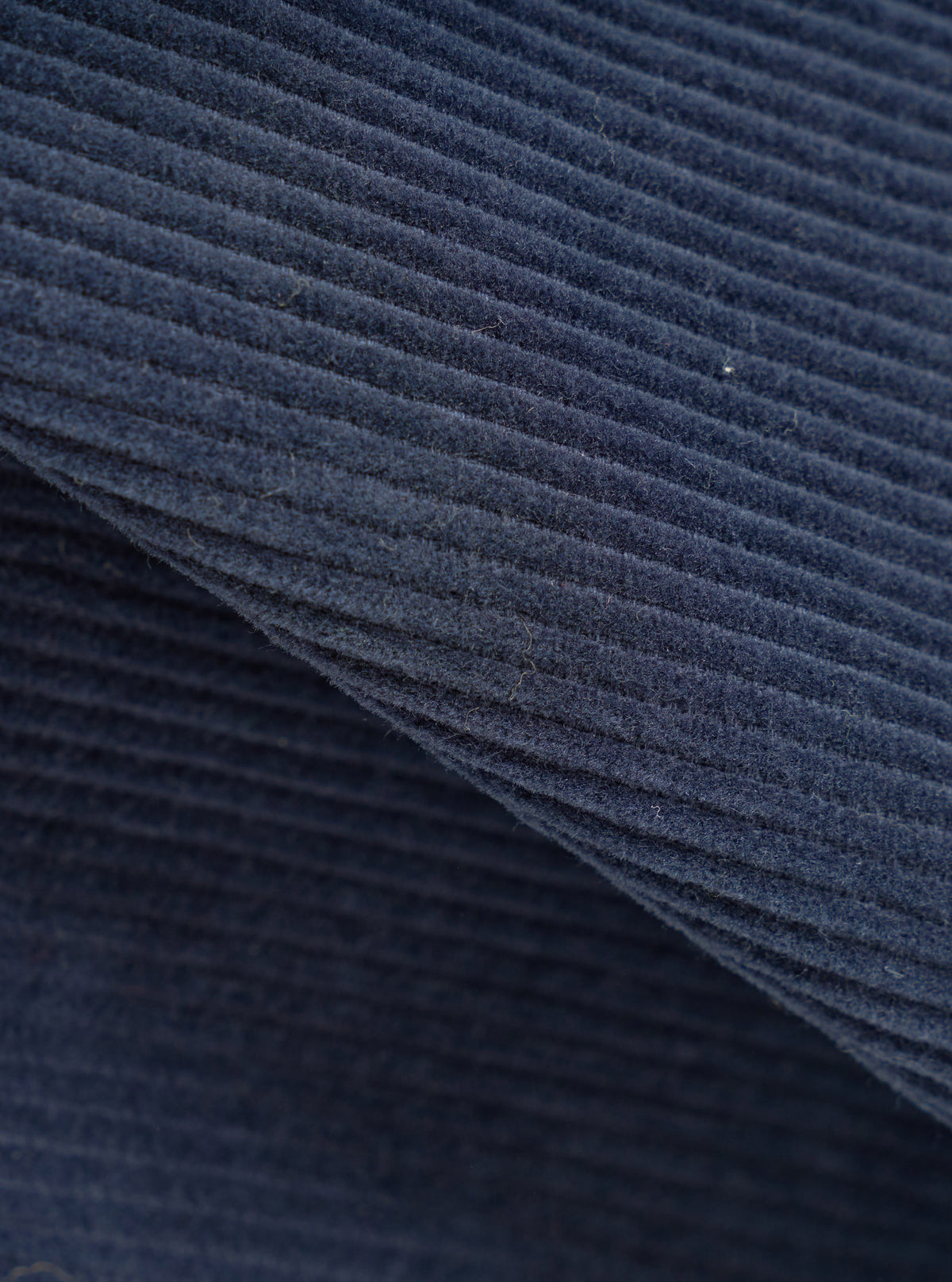 A close-up fabric swatch image of the Dark Navy Cord Manor Jacket set against a neutral white background. The shot focuses on the detailed texture of the dark navy fine-wale cotton corduroy material.