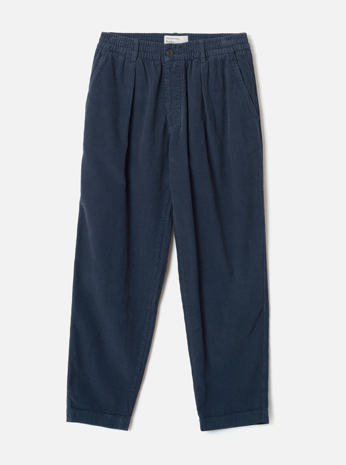 A front product shot of the Dark Navy Cord Pleated Track Pant against a plain white background. The dark blue trousers show the relaxed fit, front pleats, drawstring elastic waistband, and tapered trouser legs.