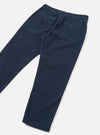 Dark navy corduroy military chinos laid flat on a light grey surface, shot at an angle. Fine wale cord texture is visible across both legs. The waistband features belt loops and a buttoned welt back pocket. The tapered legs end in plain, unfolded hems.
