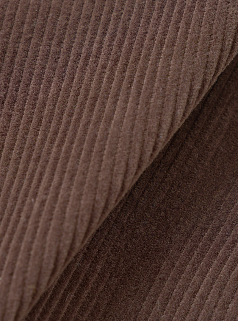 Extreme close-up fabric swatch of the Cacao Cord Three Button Jacket, fill-frame shot against a plain background. The detail showcases the ribbed wale texture, soft velvet finish, and deep brown hue of the pure cotton corduroy.