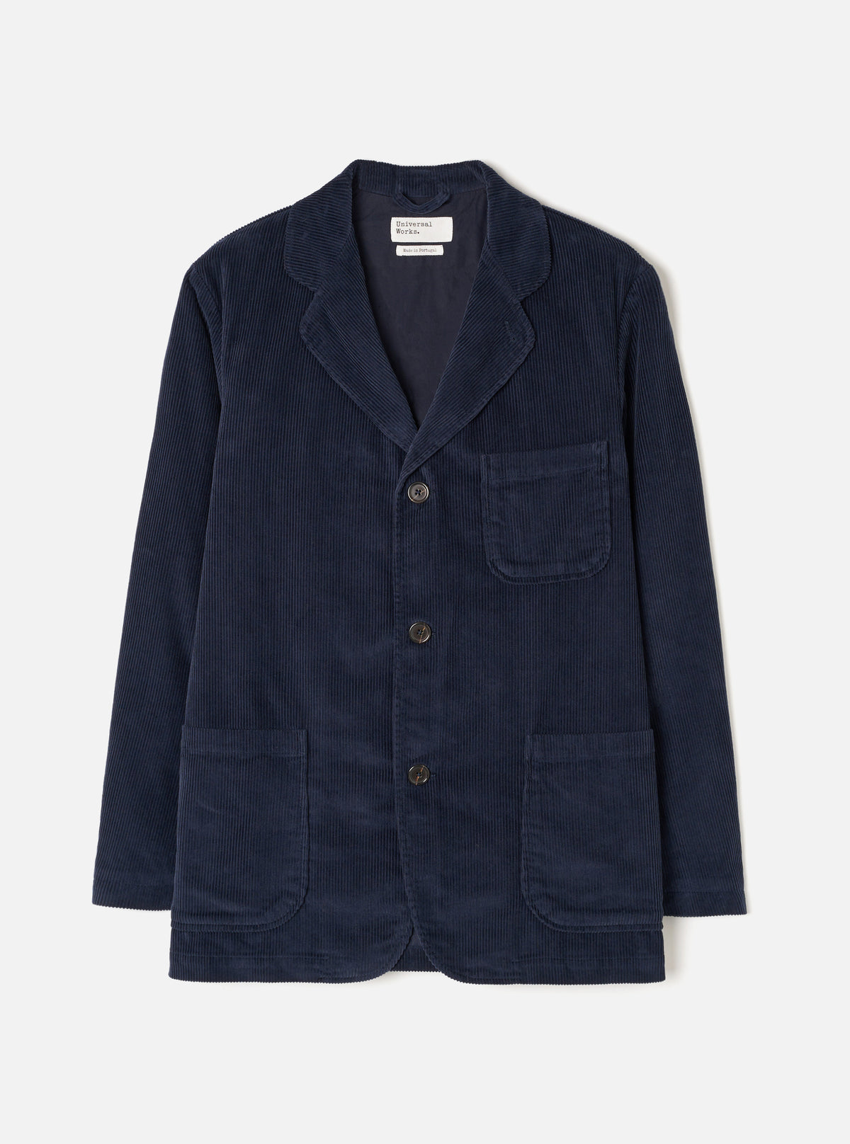 Front view of the Dark Navy Cord Three Button Jacket worn by a model against a plain studio background. The jacket features three front buttons, notch lapels, three open patch pockets, and dark navy cotton corduroy fabric.