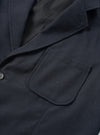 Angled side view of the Dark Navy Dublin Wool Mix Two Button Jacket worn by a model against a plain studio background. The photo focuses on the lapel roll, two-piece sleeve construction, and textured navy wool-blend cloth.