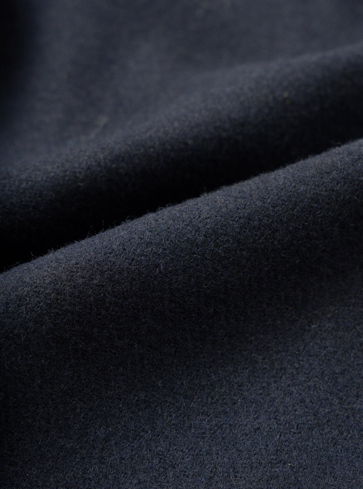 Full-frame close-up swatch showing the fabric detail of the Dark Navy Dublin Wool Mix Two Button Jacket. The image highlights the fine woven texture, dark navy heathered weave, and premium wool-blend suiting material.