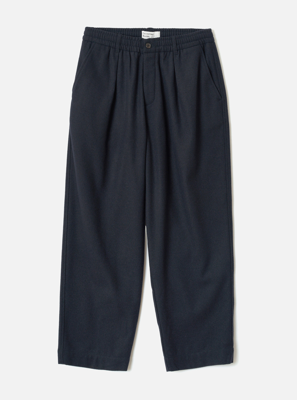 Front view of the Dark Navy Dublin Wool Mix Oxford Pant worn by a model against a plain studio background. The trousers show a wide-leg cut, single front pleats, drawstring waist, and dark navy blue wool-blend fabric.