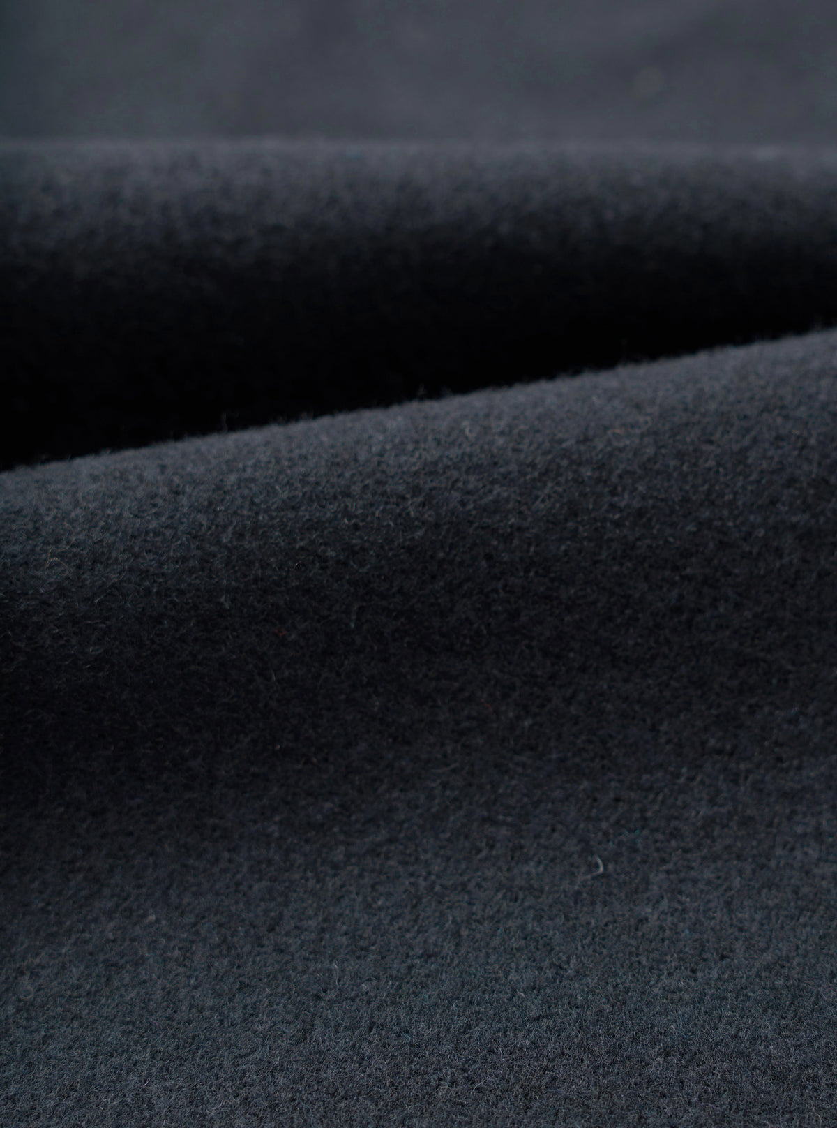 Close-up swatch view displaying the fabric weave of the Dark Navy Dublin Wool Mix Oxford Pant. The shot fills the frame, showcasing the fine dark navy heathered texture and soft wool-blend weave of the trousers.