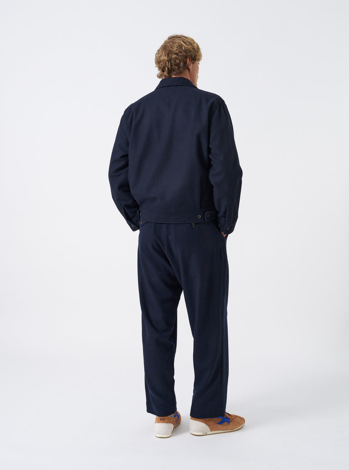 A male model wears the Dark Navy Dublin Wool Mix Rose Bowl Jacket unbuttoned, captured in a three-quarter pose against a plain white studio background. The shot details the front pockets and relaxed fit.
