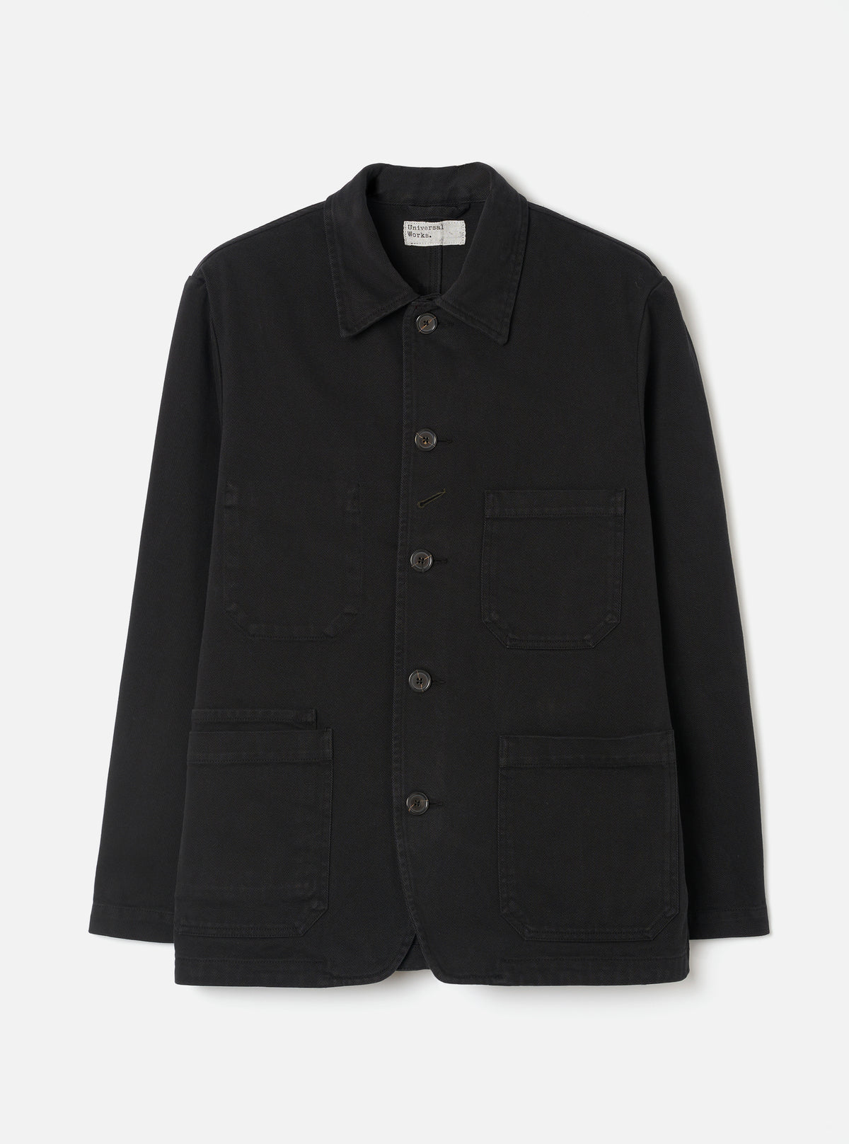 Front view of the Black Dexter Twill OG Bakers Chore Jacket displayed against a plain off-white background. The shot highlights the classic collar, contrast front buttons, and multiple functional patch pockets.