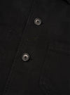 Close-up detail view of the Black Dexter Twill OG Bakers Chore Jacket against a plain white background. The image emphasizes the fine texture of the black organic cotton twill, button closure, and front patch pocket stitching.