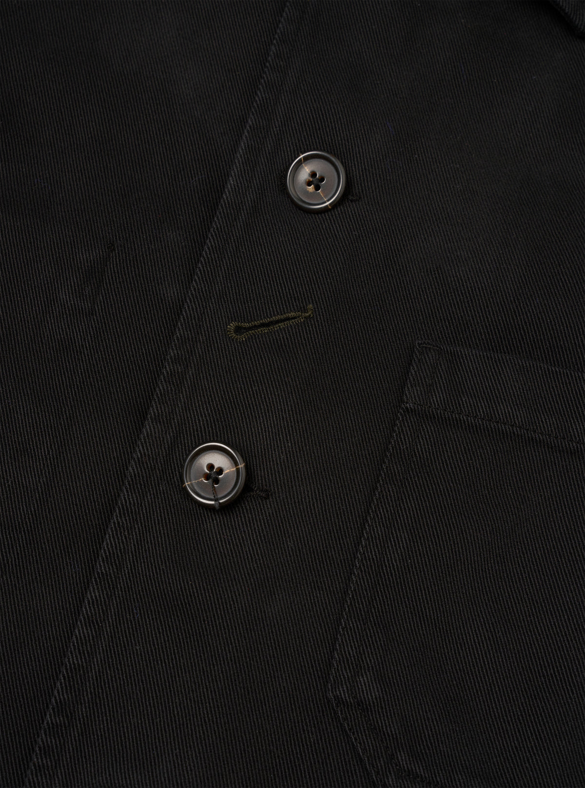 Close-up detail view of the Black Dexter Twill OG Bakers Chore Jacket against a plain white background. The image emphasizes the fine texture of the black organic cotton twill, button closure, and front patch pocket stitching.