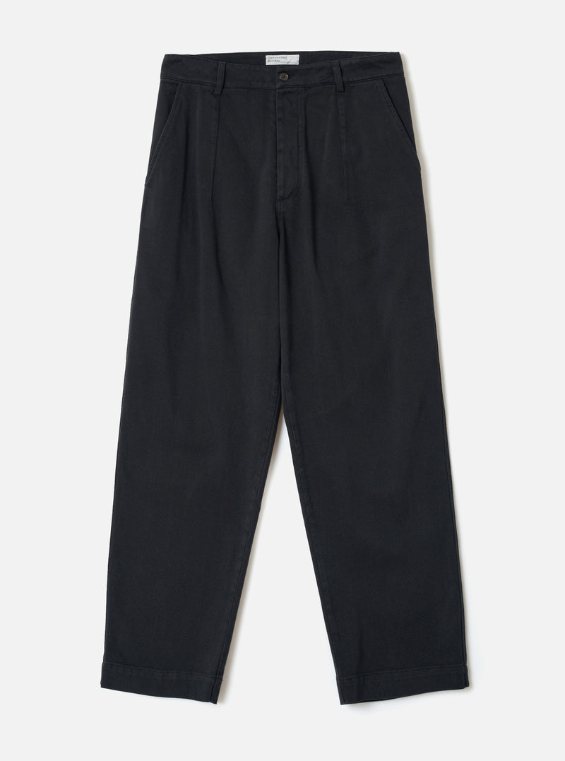 Front view of the Black Dexter Twill Grad Chino displayed against a plain off-white background. The shot showcases the fixed waistband, button closure, side pockets, and loose tapered leg silhouette of the garment.