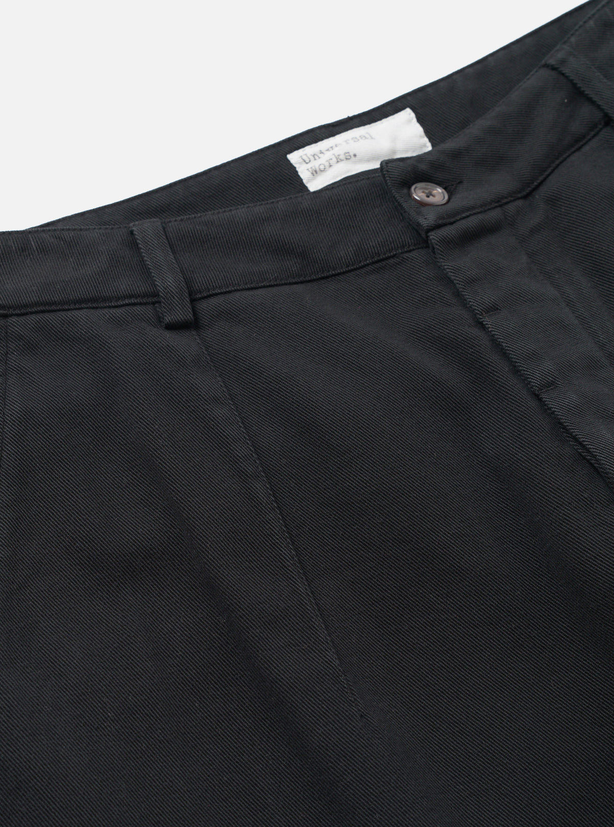 Close-up detail view of the Black Dexter Twill Grad Chino set against a white background. The image highlights the detailed stitching, waistband belt loops, pocket edges, and dark black organic cotton twill weave texture.