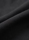 A close-up fabric swatch view displaying the rich texture and fine weave of the organic cotton twill fabric from the Black Dexter Twill Grad Chino. The frame is filled entirely with dark black twill fabric detail.