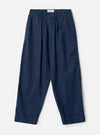 Front view of the Indigo Future Denim Oxford Pant displayed against a plain off-white background. The image details the single pleat front, elasticated waistband with drawstring, and relaxed wide leg shape.