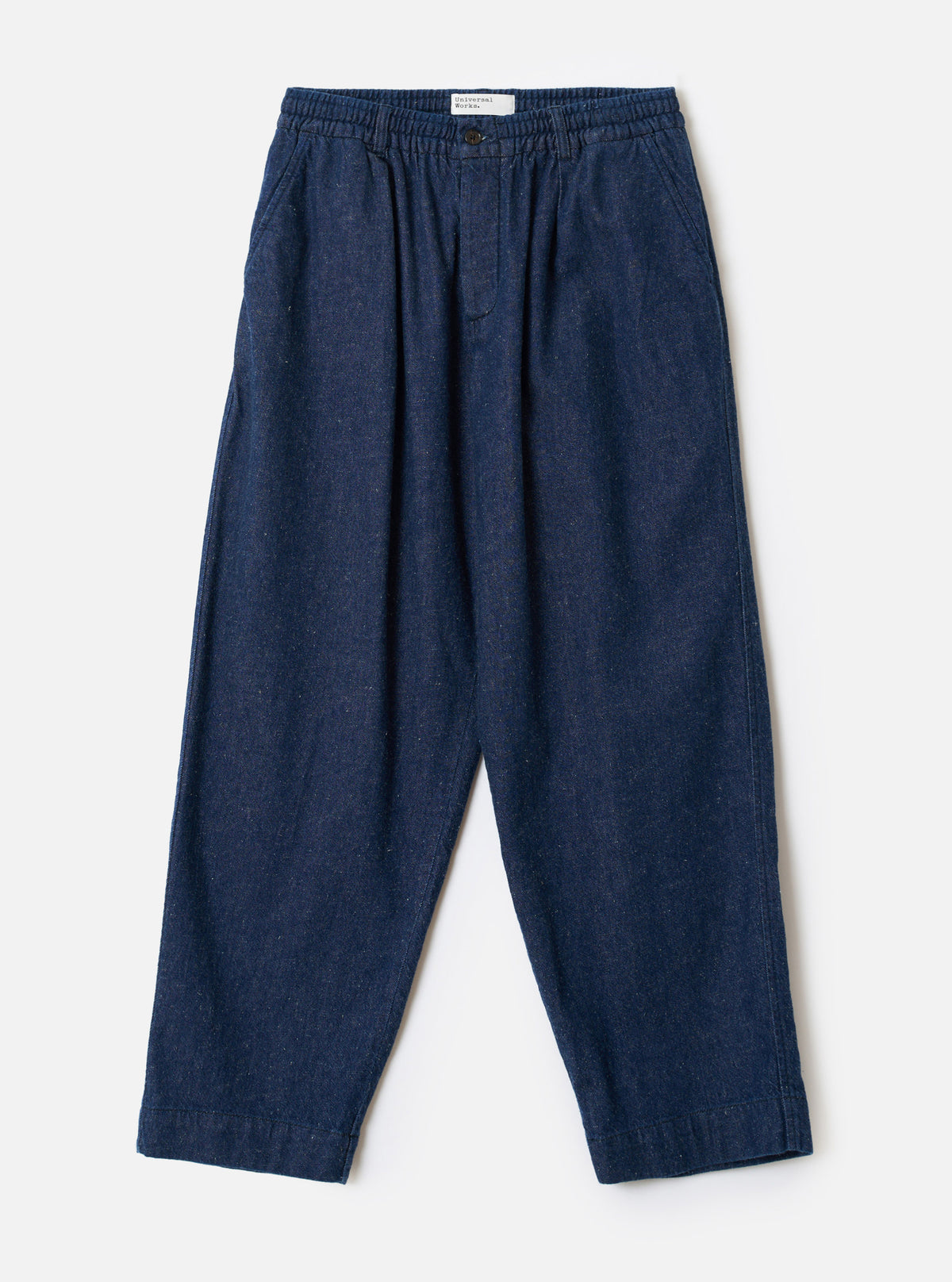 Front view of the Indigo Future Denim Oxford Pant displayed against a plain off-white background. The image details the single pleat front, elasticated waistband with drawstring, and relaxed wide leg shape.