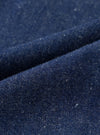 A close-up fabric swatch shot showing the rich indigo color and slubby nep surface texture of the recycled and organic cotton fabric used for the Indigo Future Denim Oxford Pant. The frame is filled with fabric.