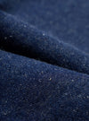 A close-up fabric swatch image capturing the deep indigo shade and textured neps of the organic and recycled cotton denim material used on the Indigo Future Denim Grad Chino. The frame is filled with denim.