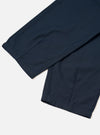 A close-up view of the Navy Slub Sateen Utility Pant against a plain off-white background, highlighting the diagonal front pockets, waistband with belt loops, zip fly details, and fine cotton slub texture.