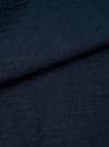A detailed close-up fabric swatch revealing the slub sateen weave in dark navy blue. The image fills the entire frame, highlighting the rich color, fine surface texture, and cotton material details.