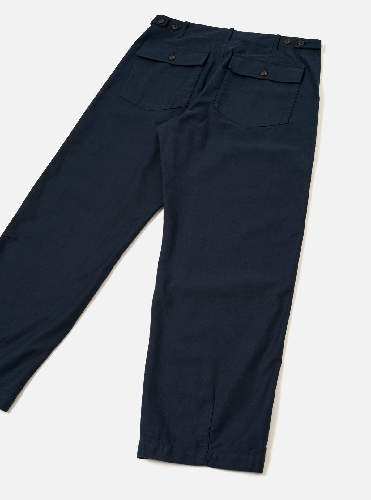 Rear view of the Navy Slub Sateen Loose Fatigue Pant displayed against a plain light background. The shot showcases the rich navy slub sateen fabric texture, practical flap back pockets, rear seams, and wide straight-leg trouser opening.