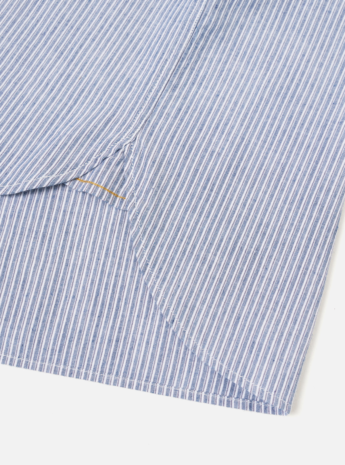 Close-up detail shot of the Blue Montgomery Stripe Station Shirt against a neutral backdrop. The image emphasizes the fine woven cotton stripe texture, precise stitching along the chest pocket, and high-quality front button closures.