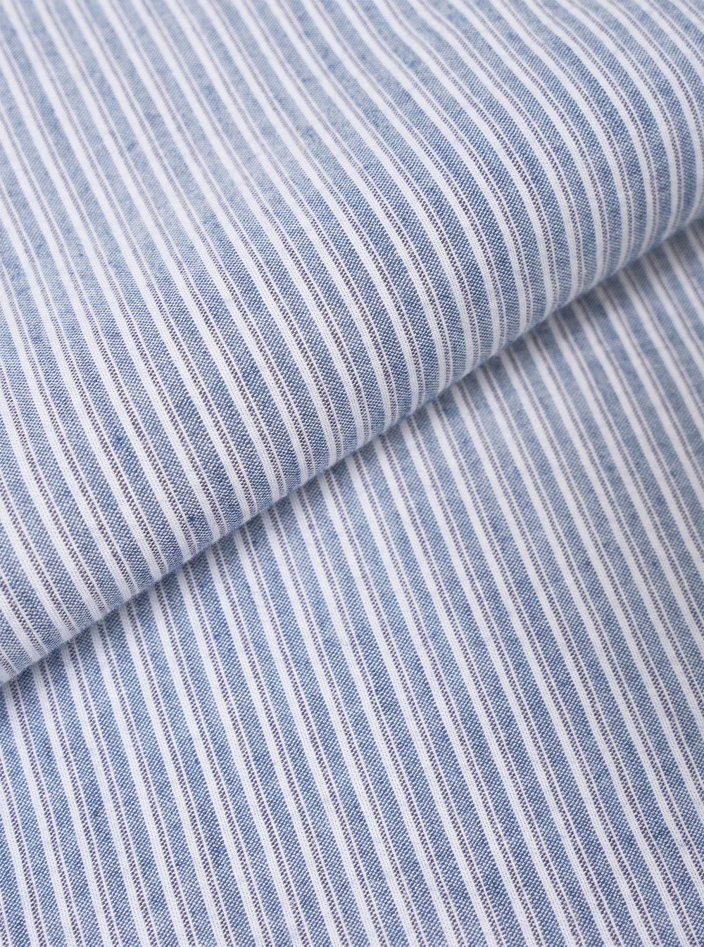 Close-up fabric swatch image detailing the fine texture and pattern of the Blue Montgomery Stripe Station Shirt. The image fills the frame to show the woven cotton fabric, distinct blue and light stripe structure, and smooth material weave.