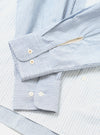 Close-up flat lay of the Mix Stripes WM Station Shirt in blue and white. Two barrel cuffs are shown overlapping, each fastened with two mother-of-pearl buttons. The woven fabric features fine vertical blue and white stripes with a slightly textured surface. Shot on a white studio surface.