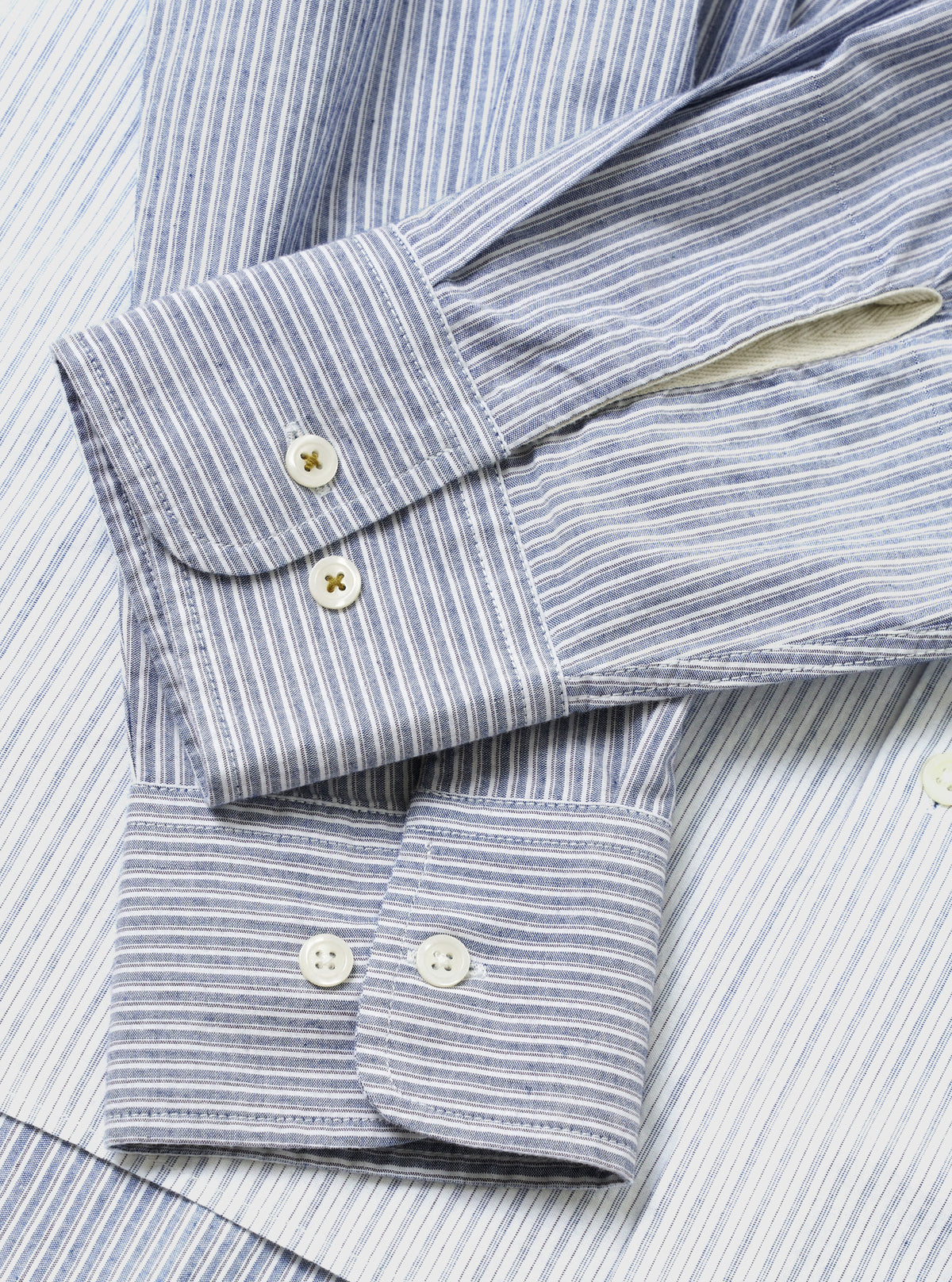 A detailed view of the Mix Stripes WM Station Shirt displayed flat against a plain white background. The image showcases the contrasting blue striped cotton fabric patterns, square chest pocket, and casual rear yoke details.