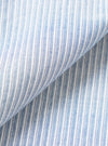 Close-up fabric detail of the Mix Stripes Station Shirt, showing a woven blue and white striped textile with a fine pin-stripe pattern. The fabric has a chambray-like texture with visible slub threads. A diagonal fold runs across the frame, revealing the fabric's drape and weight.