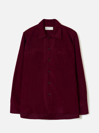 Front view of the Dark Red Dam Marl Work Shirt displayed against a plain off-white background. The shot highlights the one-piece collar, two chest flap pockets, button front closure, and curved hem silhouette.