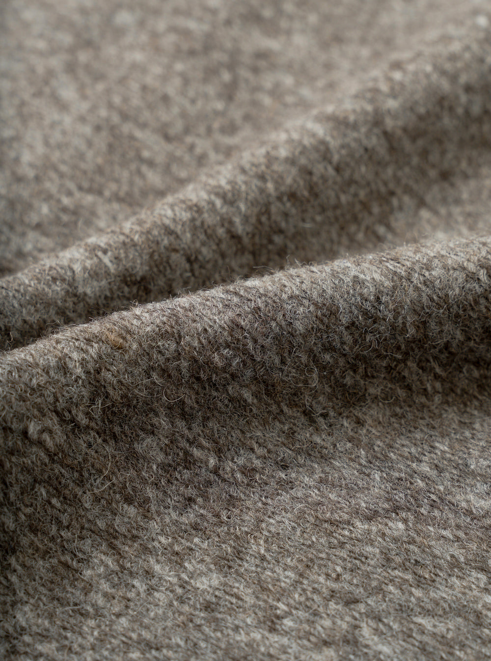 A close-up fabric swatch view showing the intricate marl weave of the Mid Brown Dam Marl Work Shirt. The frame is filled with the warm brown heathered texture and soft brushed wool-blend fleece.