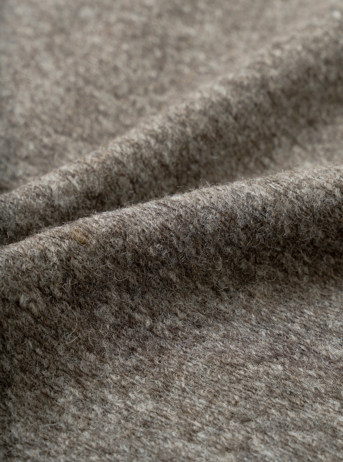 A close-up fabric swatch view showing the intricate marl weave of the Mid Brown Dam Marl Work Shirt. The frame is filled with the warm brown heathered texture and soft brushed wool-blend fleece.