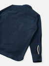 An angled view of the Navy Dam Marl Work Shirt set against a plain light background. The image showcases the structured fit, sleeve button cuffs, and deep navy heathered knit fabric detail.