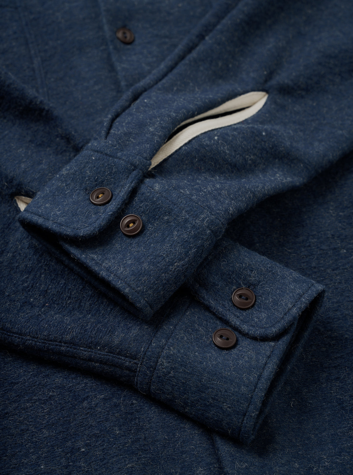 A back view of the Navy Dam Marl Work Shirt displayed flat against a plain white background. The shot highlights the clean back yoke seam construction, subtle curved hem, and soft marl finish.