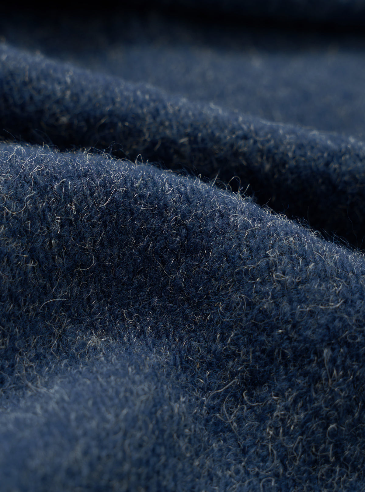 A close-up fabric swatch view showing the rich heathered texture of the Navy Dam Marl Work Shirt. The macro shot fills the frame to detail the soft brushed wool-blend fleece material in navy blue.
