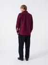 A male model wears the Dark Red Dam Marl Work Shirt unbuttoned in a three-quarter pose against a plain studio backdrop. The image details the soft drape, open collar style, and layered casual outfit.