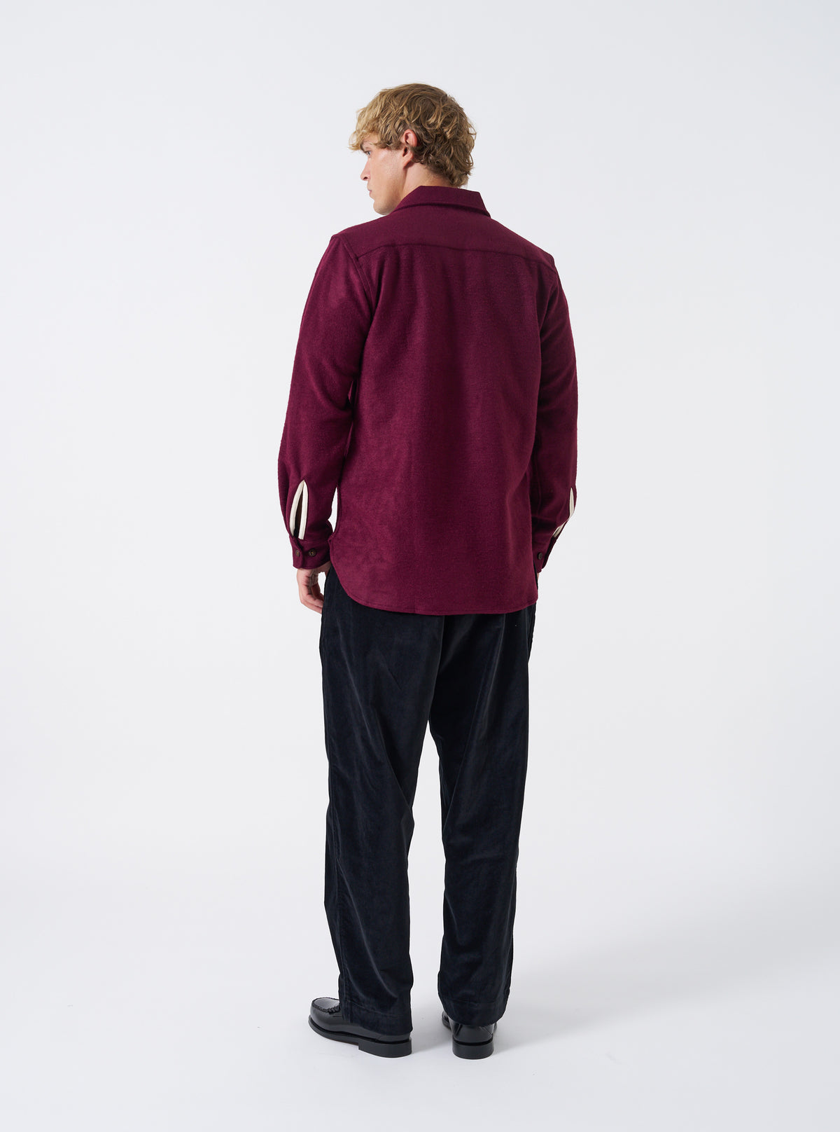 A male model wears the Dark Red Dam Marl Work Shirt unbuttoned in a three-quarter pose against a plain studio backdrop. The image details the soft drape, open collar style, and layered casual outfit.