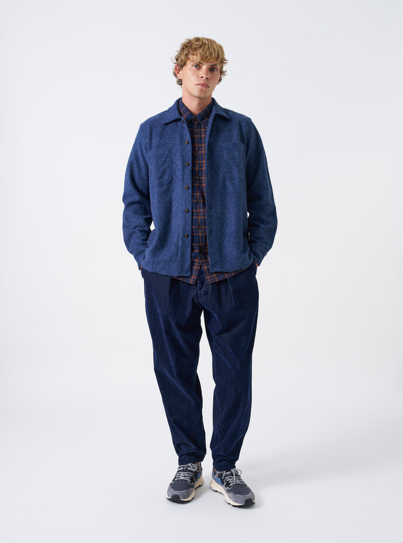 A male model wears the Navy Dam Marl Work Shirt against a plain studio background. This front view showcases the camp collar, buttoned front closure, and relaxed fit of the dark navy textured overshirt.