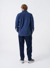 A male model is featured wearing the Navy Dam Marl Work Shirt from the back against a white background. The shot highlights the clean shoulder construction and straight hem of the dark navy garment.