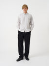 A male model stands wearing the Dove Monk Organic Stripe Square Pocket Shirt against a plain white studio background. The front view highlights the striped pattern, classic button-down front, and fit.